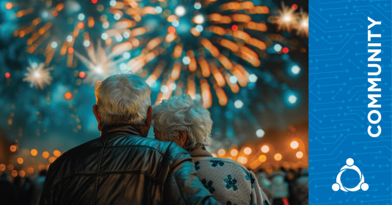 An elderly couple stands close together, watching colorful fireworks burst in the night sky. The right side of the image features a blue panel with the word “COMMUNITY” and a graphic of interconnected people.