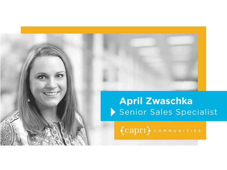 A woman smiling in a professional headshot with text: April Zwaschka, Senior Sales Specialist, Capri Communities. The background is blurred and the design includes blue and yellow accents.