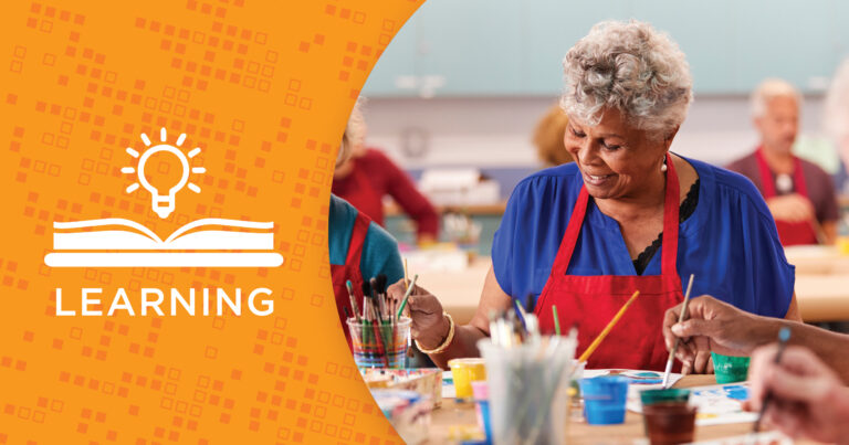 Older adults wearing aprons participate in a painting class, smiling and interacting at a table covered with art supplies. On the left, an orange graphic reads “LEARNING” with icons of a book and light bulb.