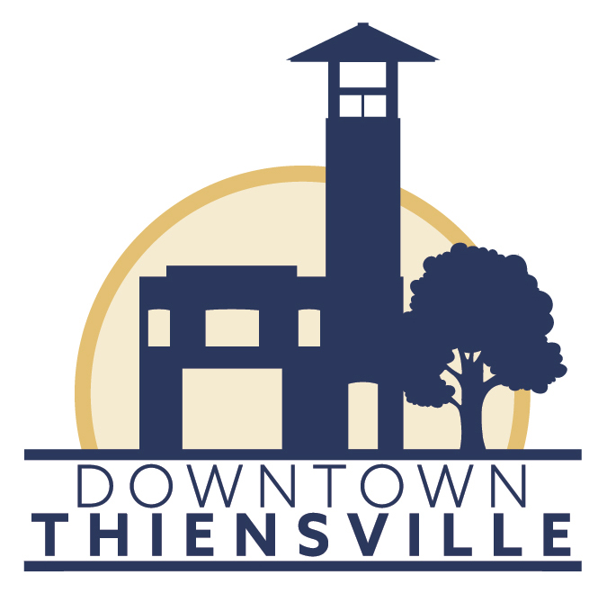 Logo for Downtown Thiensville featuring a stylized building with a tower, a large tree, and a circular background, all in navy blue and beige, with Downtown Thiensville written below.