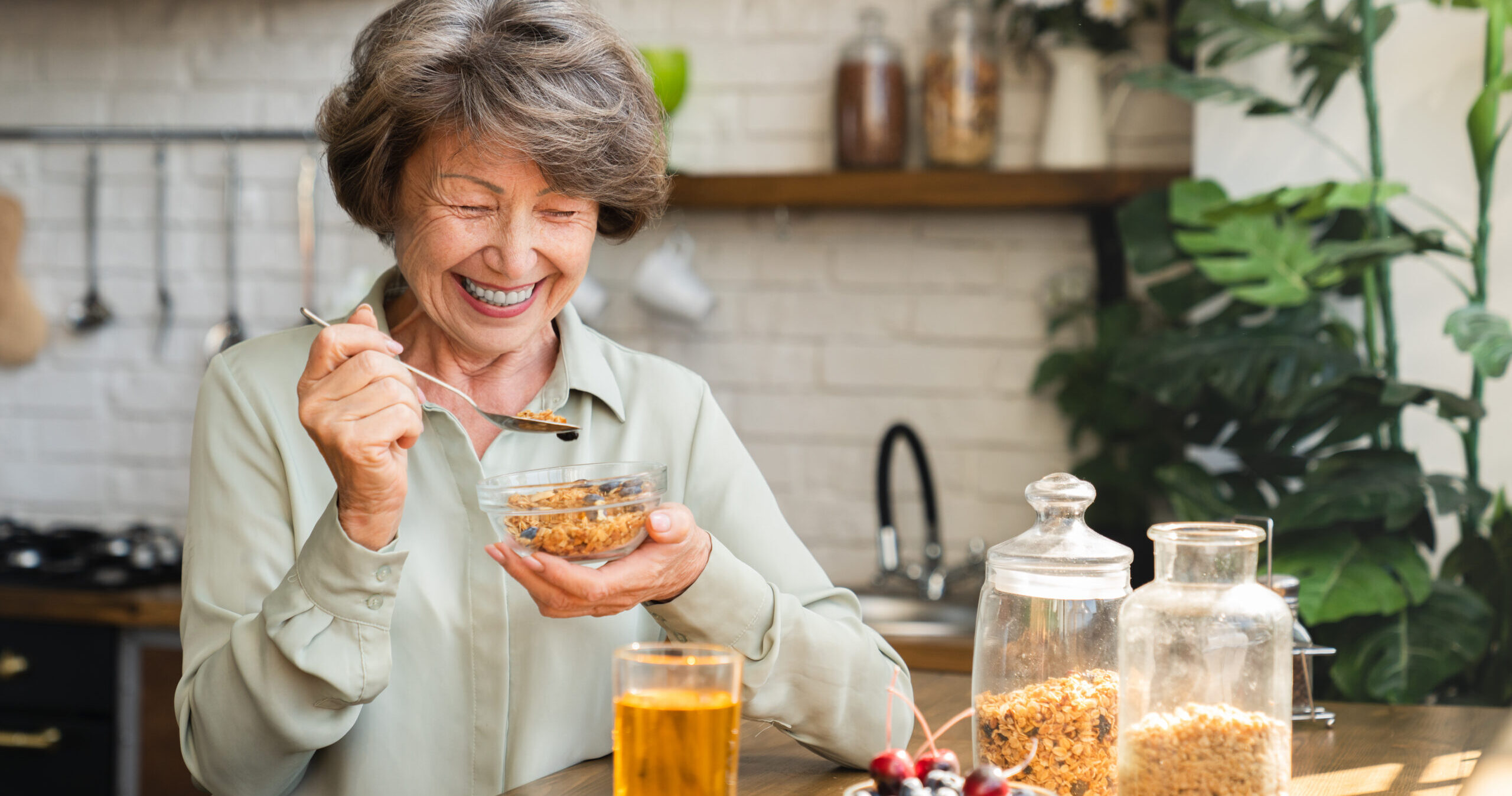 A smiling elderly women enjoying her morning breakfast and showing early signs of cognitive decline and dementia