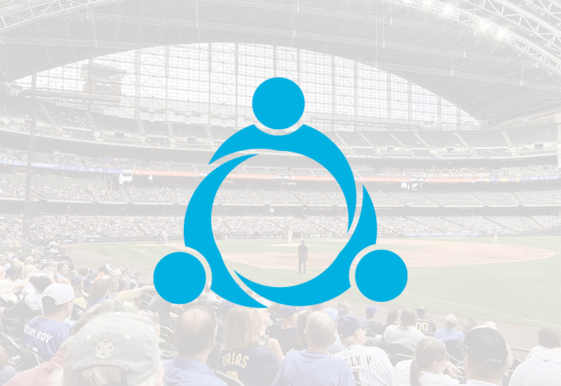 A baseball stadium filled with spectators, with a large blue abstract circular icon featuring three connected dots overlaid at the center of the image.