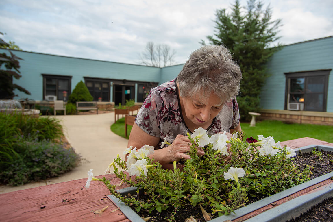 A Harbor Campus Resident Gardening in an Atrium