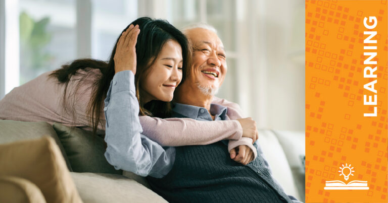 A young woman hugs an older man who is smiling while they sit on a couch at home. On the right, an orange panel with the word LEARNING and an open book with a sun icon is displayed vertically.
